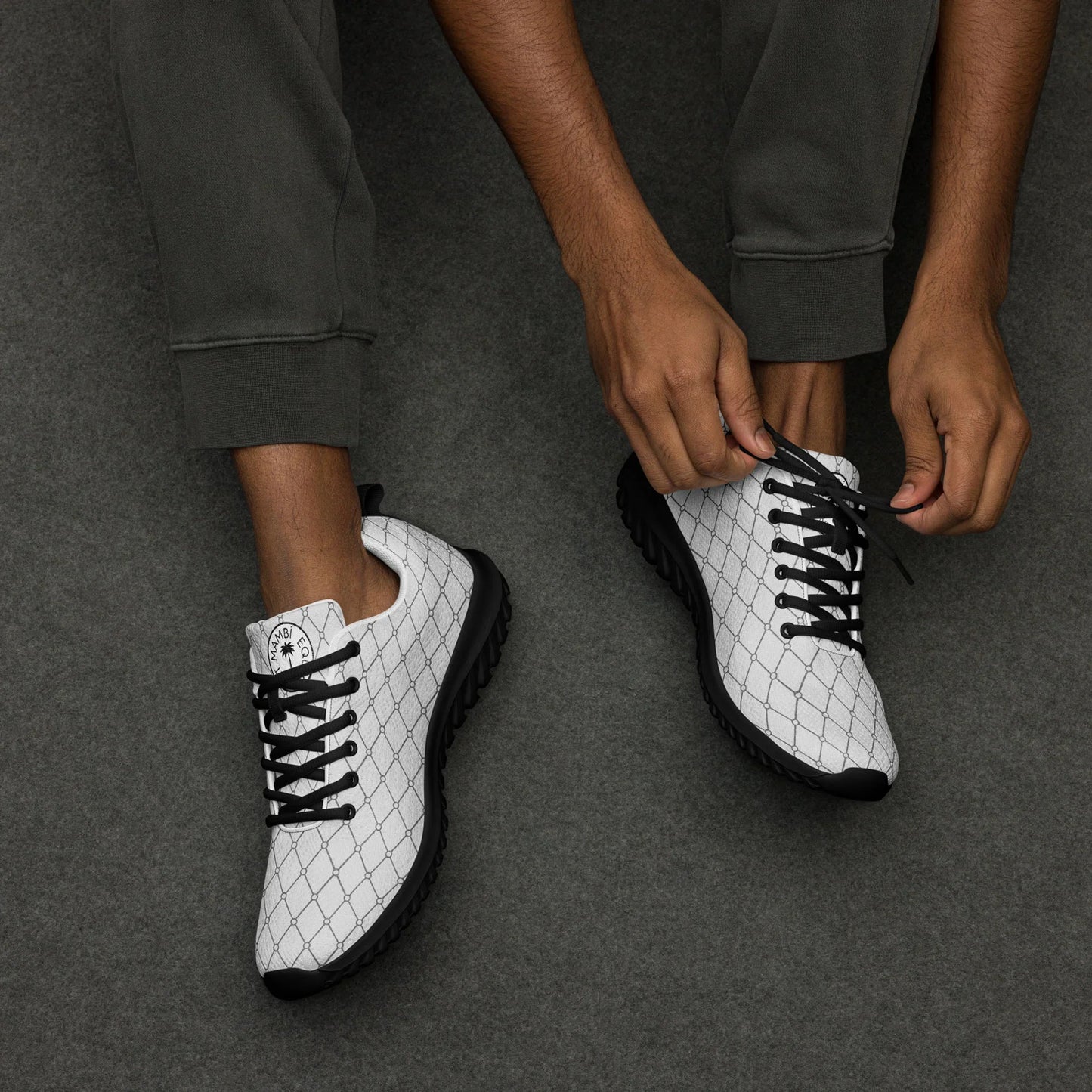 Man tying laces on white Mercury men's athletic shoes with black sole and grid pattern