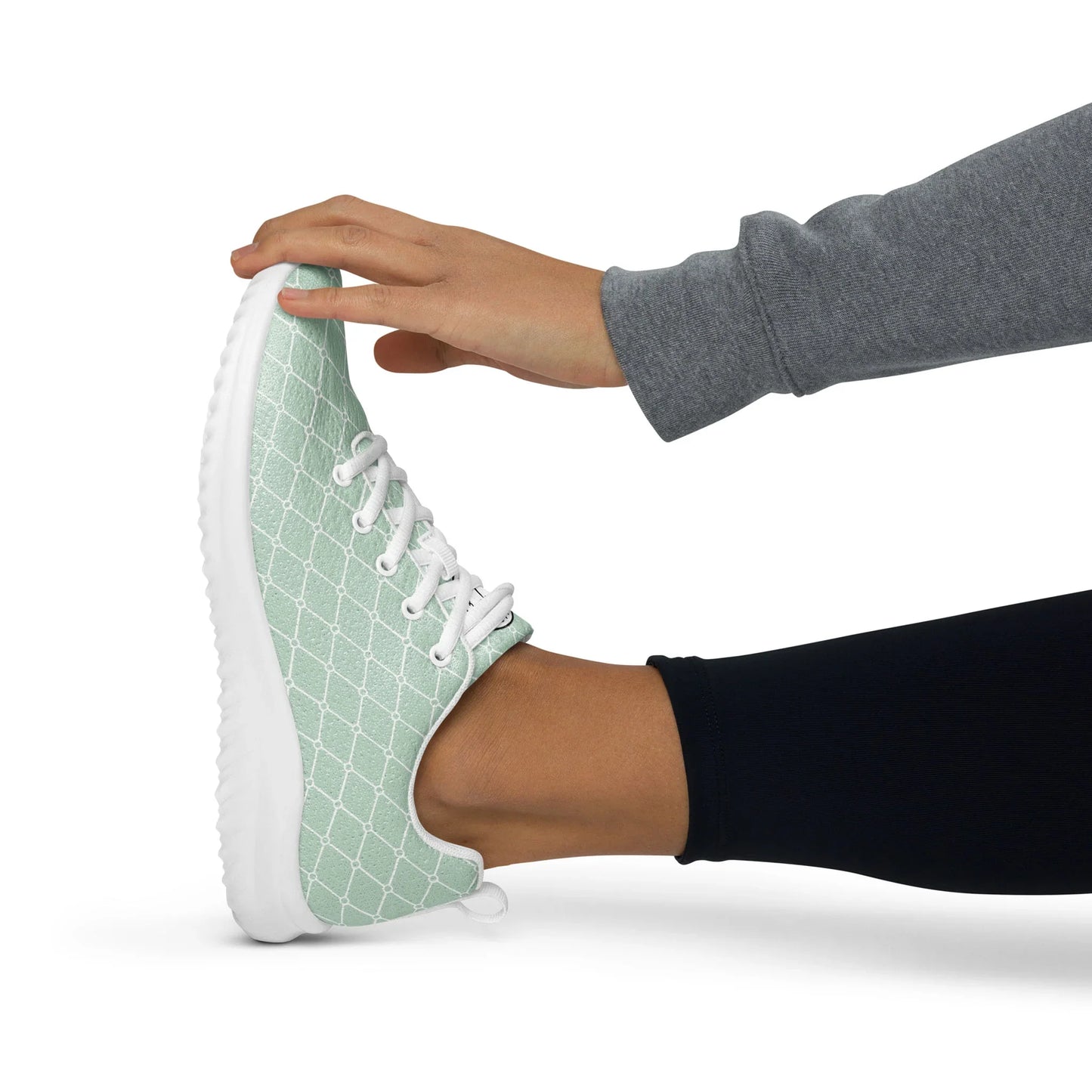 Woman stretching in mint green patterned women's athletic shoes with white soles