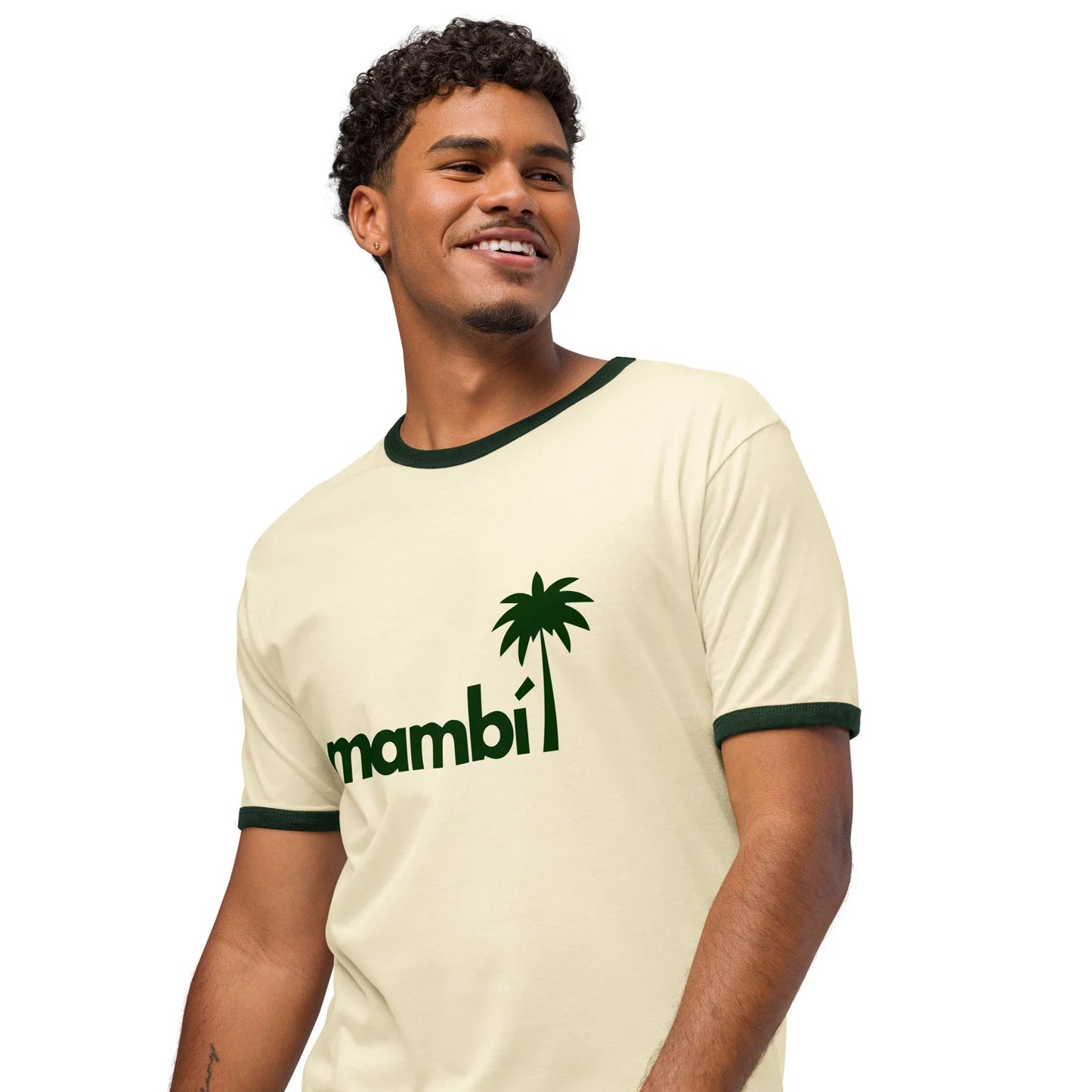 A smiling man wears a cream-colored retro t-shirt with dark green trim. This lightweight cotton tee features the word mambi in lowercase letters and a palm tree graphic, offering a relaxed fit and vintage-inspired style.