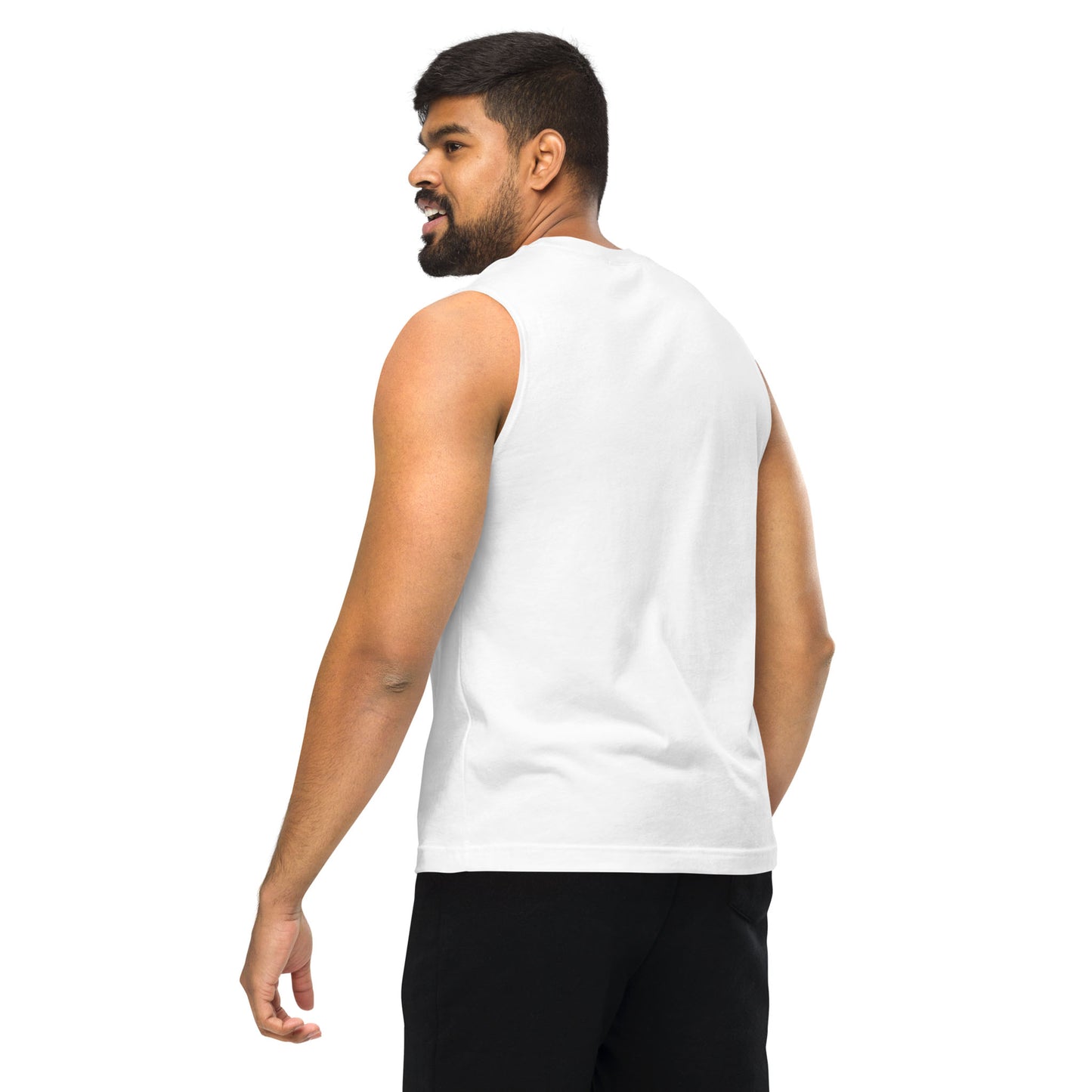 A man with short hair and a beard wears a relaxed fit, sleeveless tank and black shorts, standing and looking over his shoulder against a plain white background—perfect attire for a yoga class.