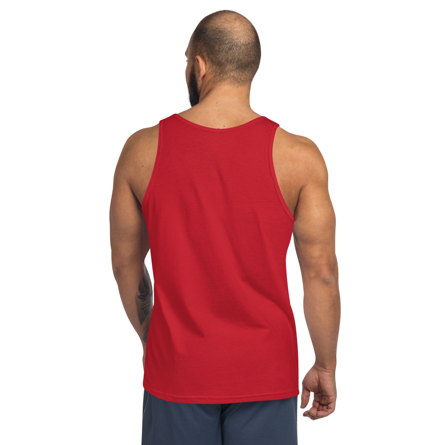 A man with a shaved head and beard is shown from the back, wearing a classic ringspun cotton tank top in red and dark shorts, standing against a plain white background.