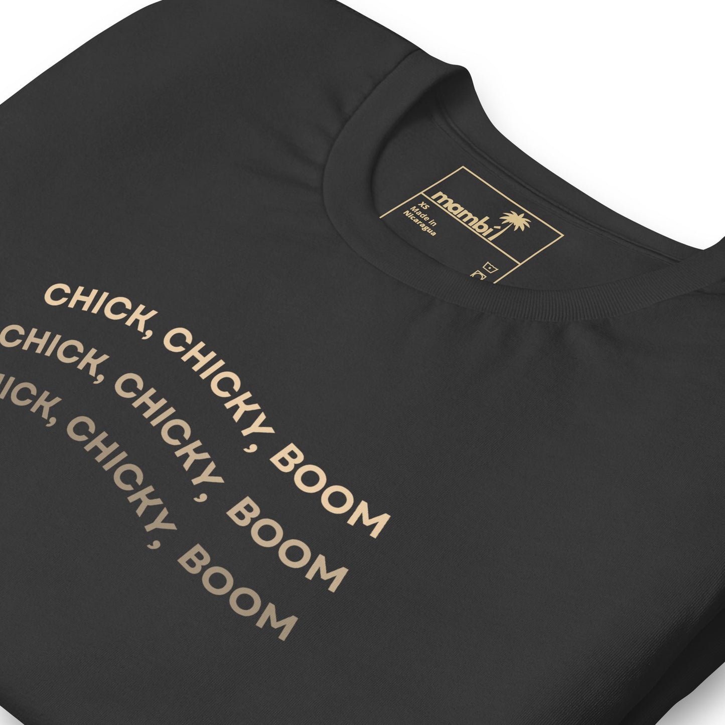 A black fitted shirt with beige text that repeats CHICK, CHICKY, BOOM three times in bold uppercase letters. This comfortable cotton graphic tee features an inside label with the Mambu brand and a palm tree logo.