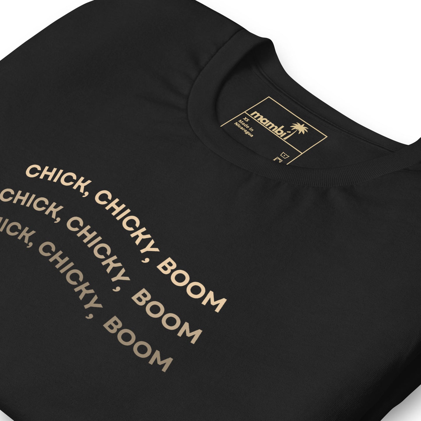 A black fitted shirt made from comfortable cotton, featuring CHICK, CHICKY, BOOM repeated three times in bold beige letters. The mambi label with a palm tree logo and size info adds a unique touch to this graphic tee.