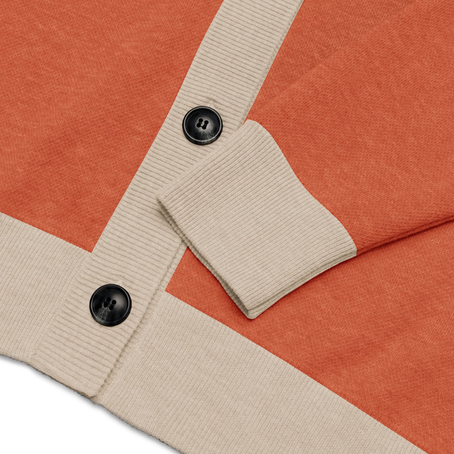 A close-up of a stylish two-tone cardigan in orange with beige ribbed cuffs and trim, featuring two large black buttons.