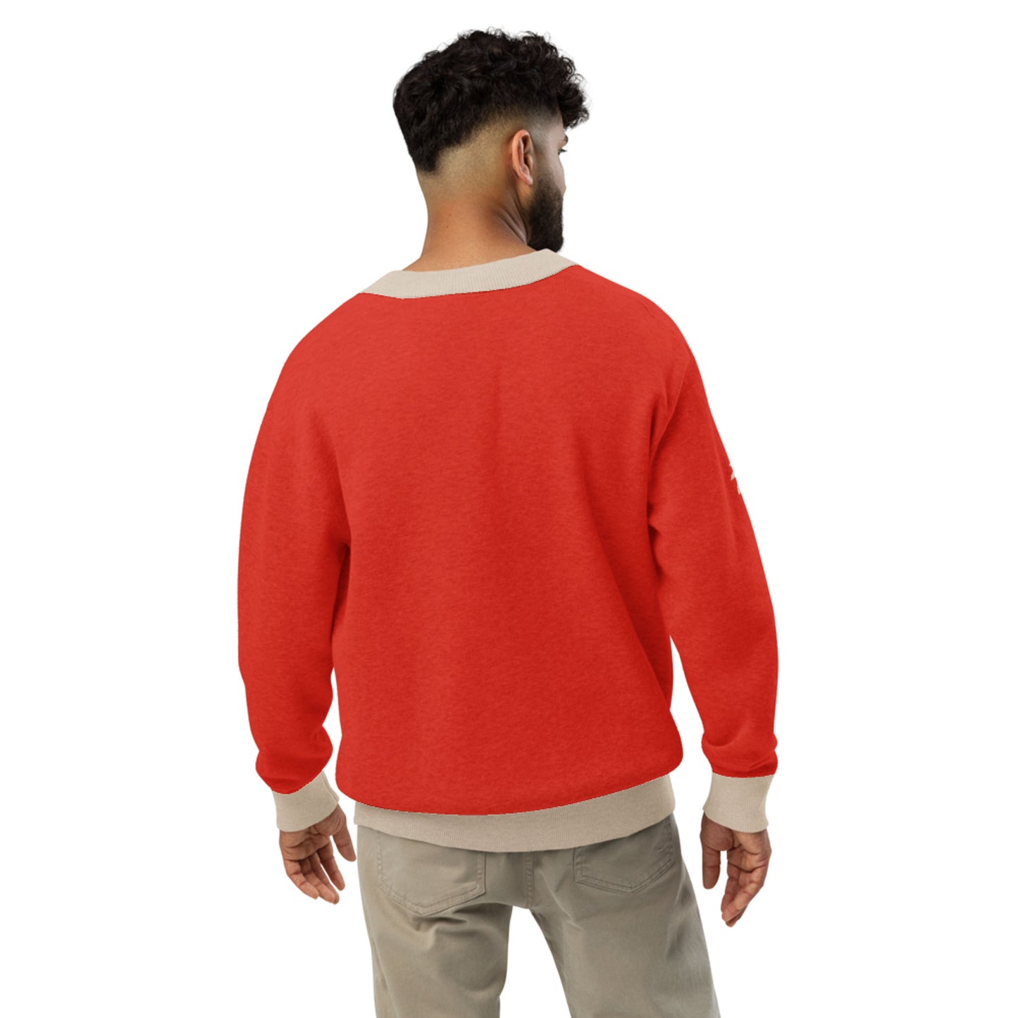 A man with short, curly hair stands with his back to the camera, wearing a two-tone cardigan with beige cuffs and collar, and light-colored pants against a plain white background.
