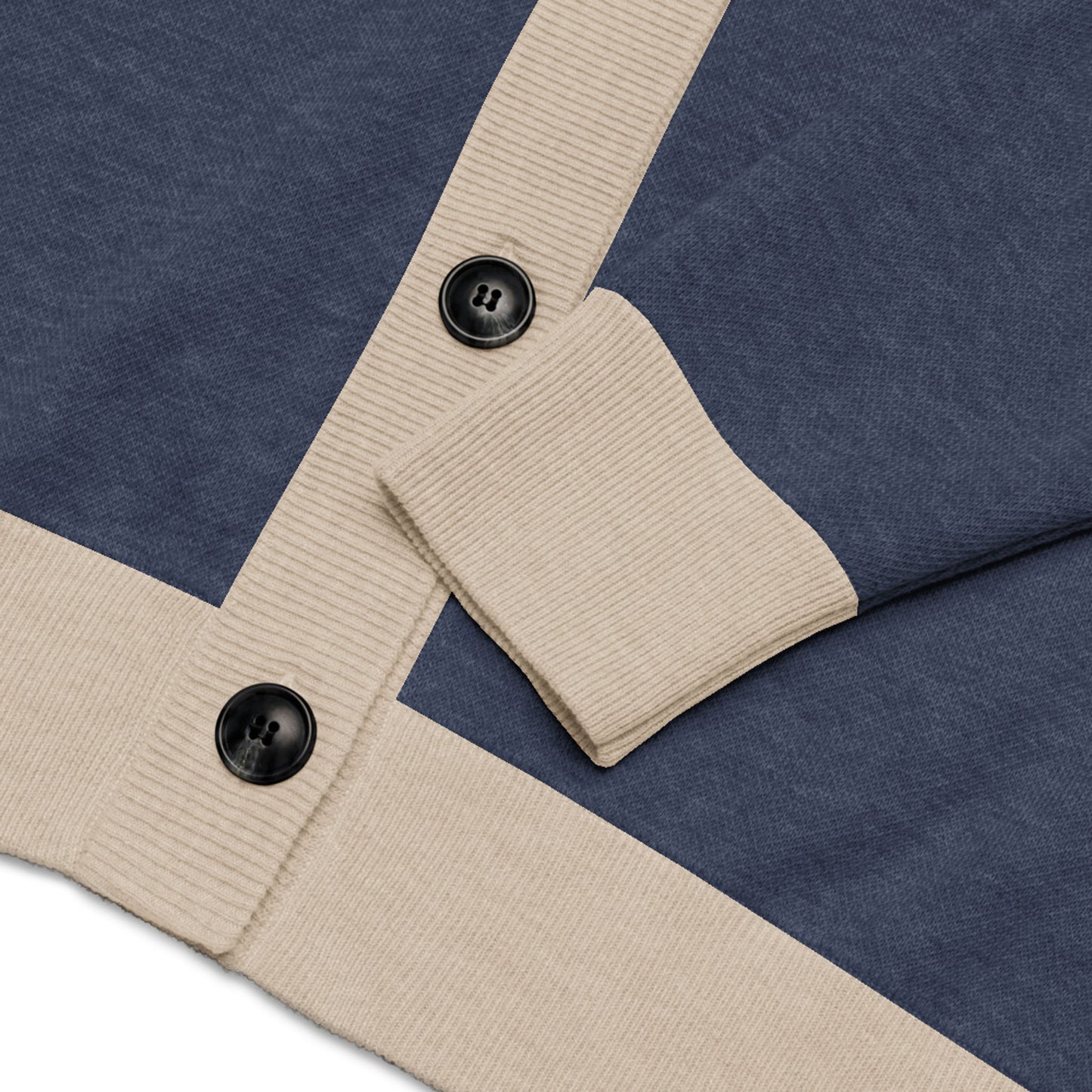 A close-up of a soft jacquard knit blue cardigan with beige ribbed cuffs and button placket, featuring two large black buttons.