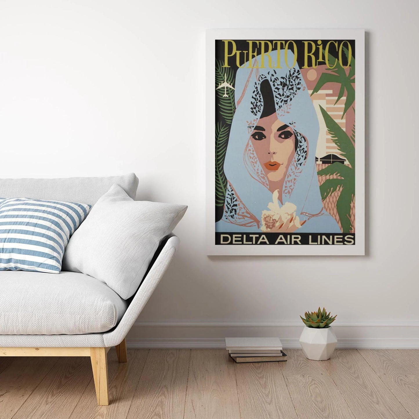 The Puerto Rico Reprinted Vintage Poster by Printful (24x36, premium luster paper) features a woman in a blue shawl, framed and displayed above a modern sofa with striped pillows, accompanied by books and a small plant.