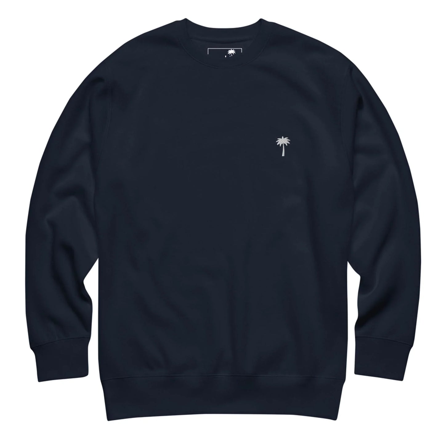 A plain, dark navy blue Mambí crewneck sweatshirt with long sleeves and a small white palm tree logo on the left chest area.