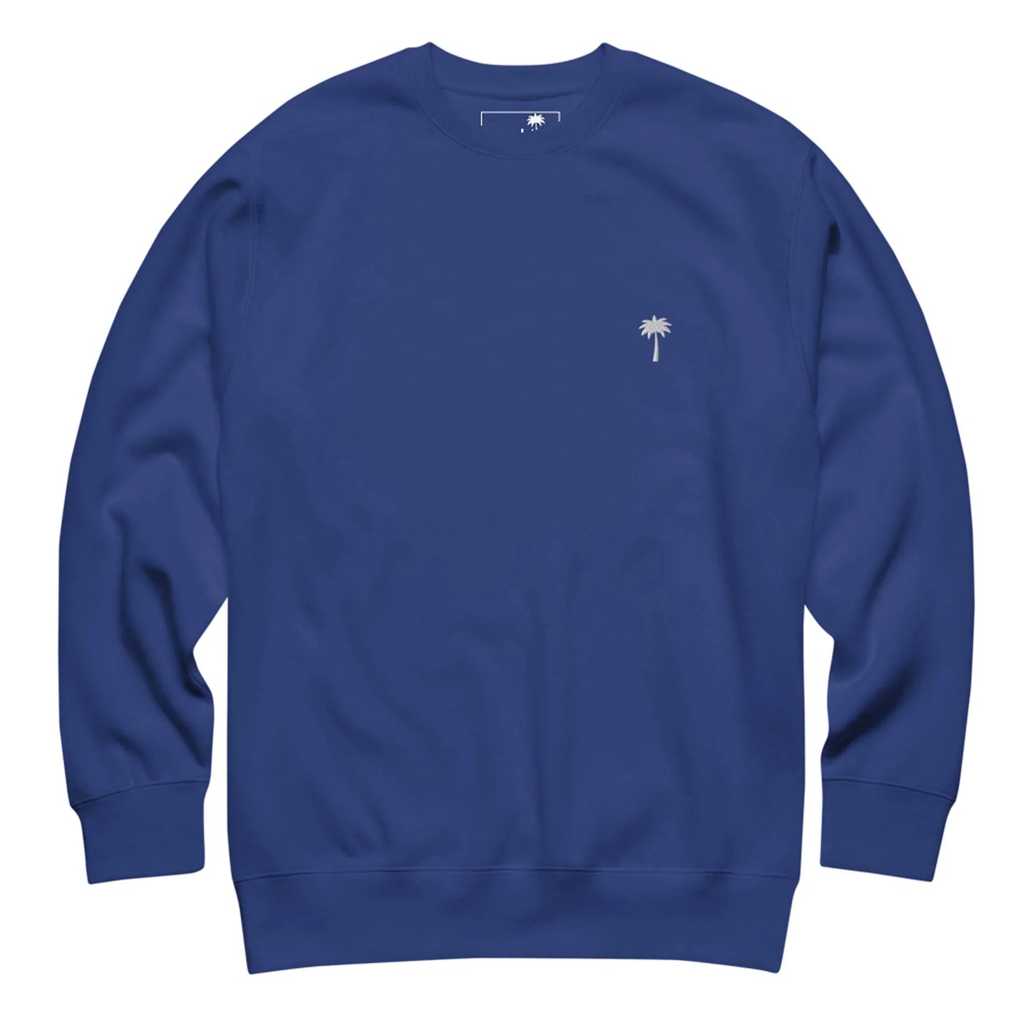 A plain blue crewneck sweatshirt featuring a small white palm tree emblem on the left chest, inspired by Mambí style.