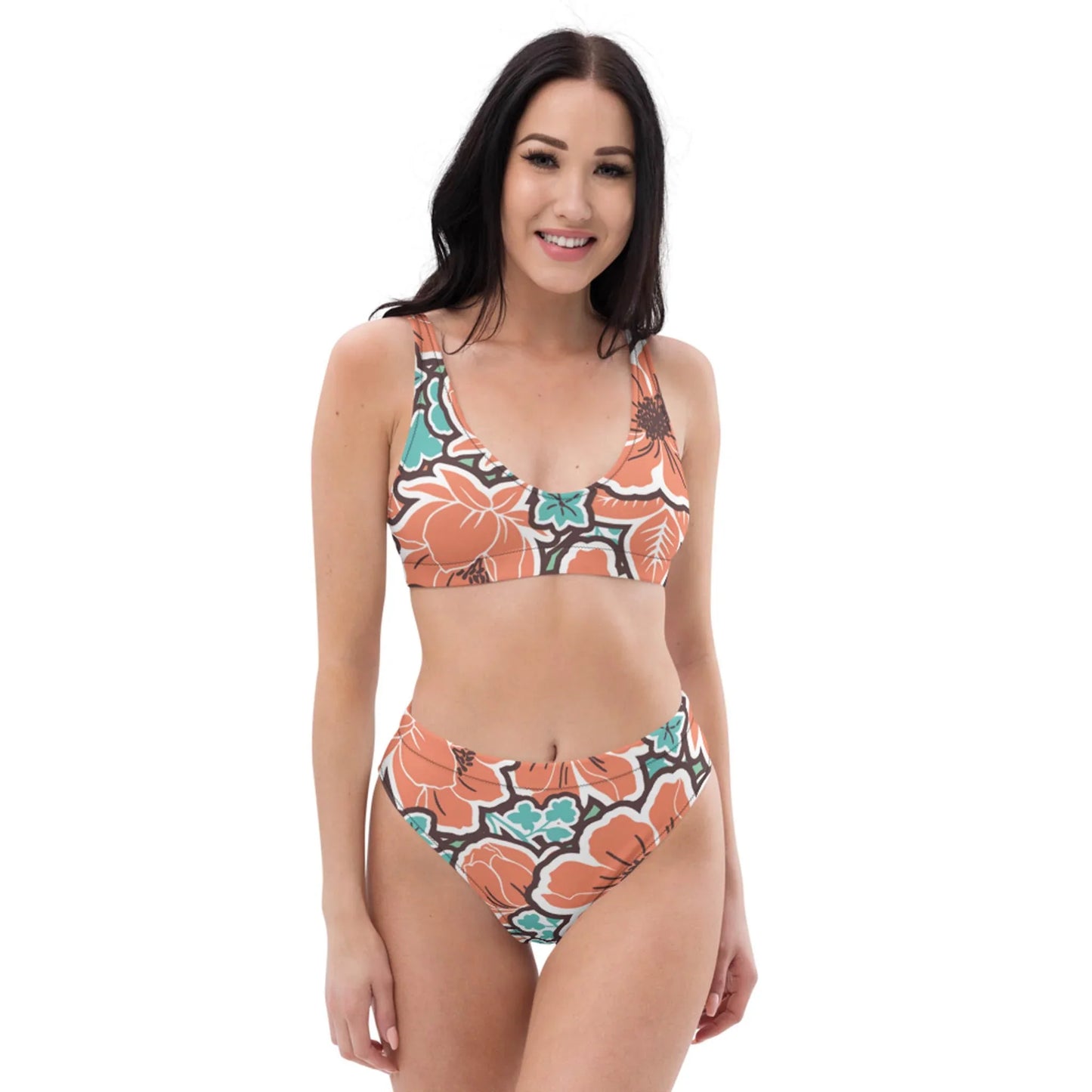 A woman with long dark hair smiles while wearing the Valeria High-Waisted Bikini Swimsuit by Printful, featuring colorful orange, green, and white patterns, against a plain white background.