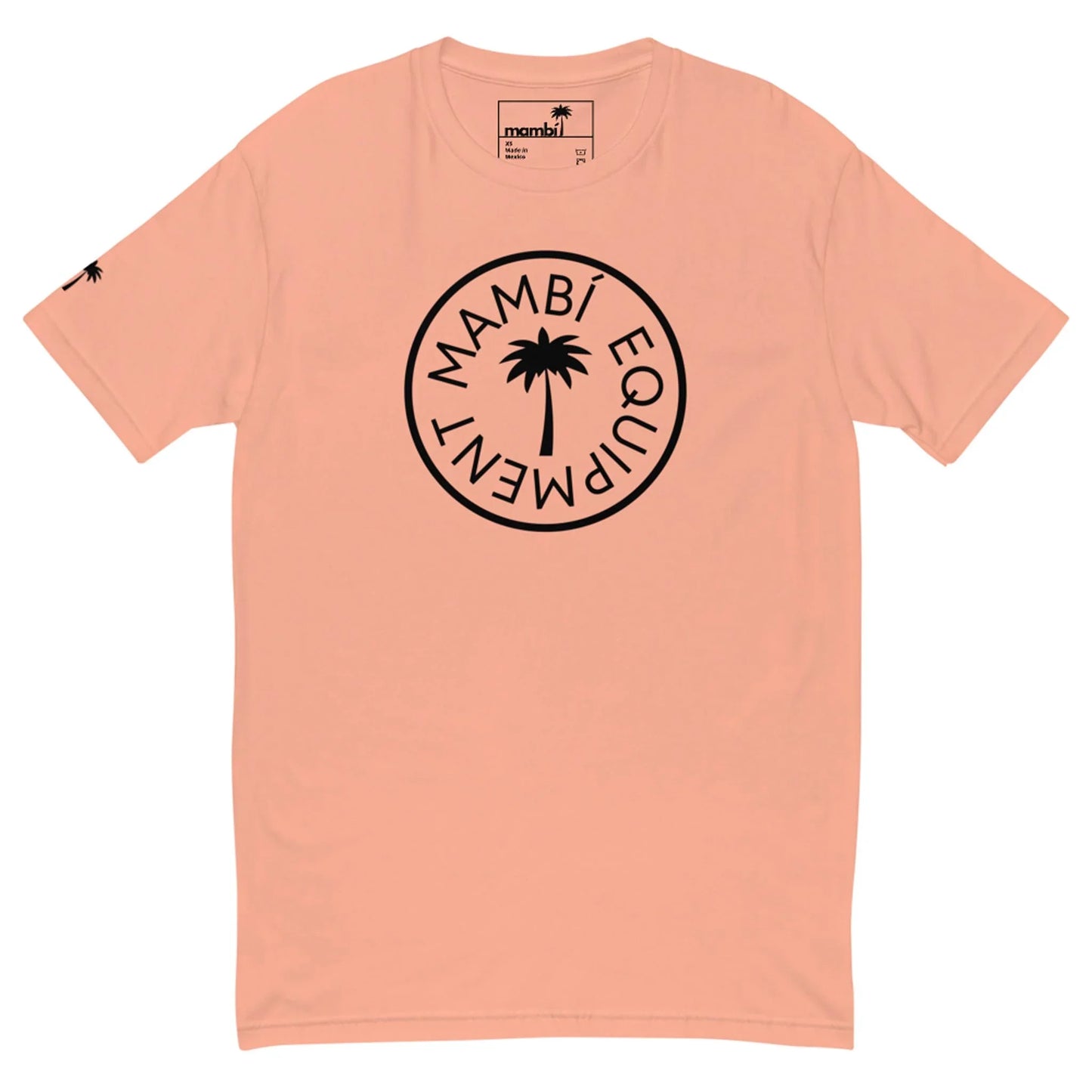 Peach-colored Mambí T-shirt featuring a black circular logo with a palm tree in the center and “MAMBÍ EQUIPMENT” around it; a small black palm tree decorates the left sleeve.