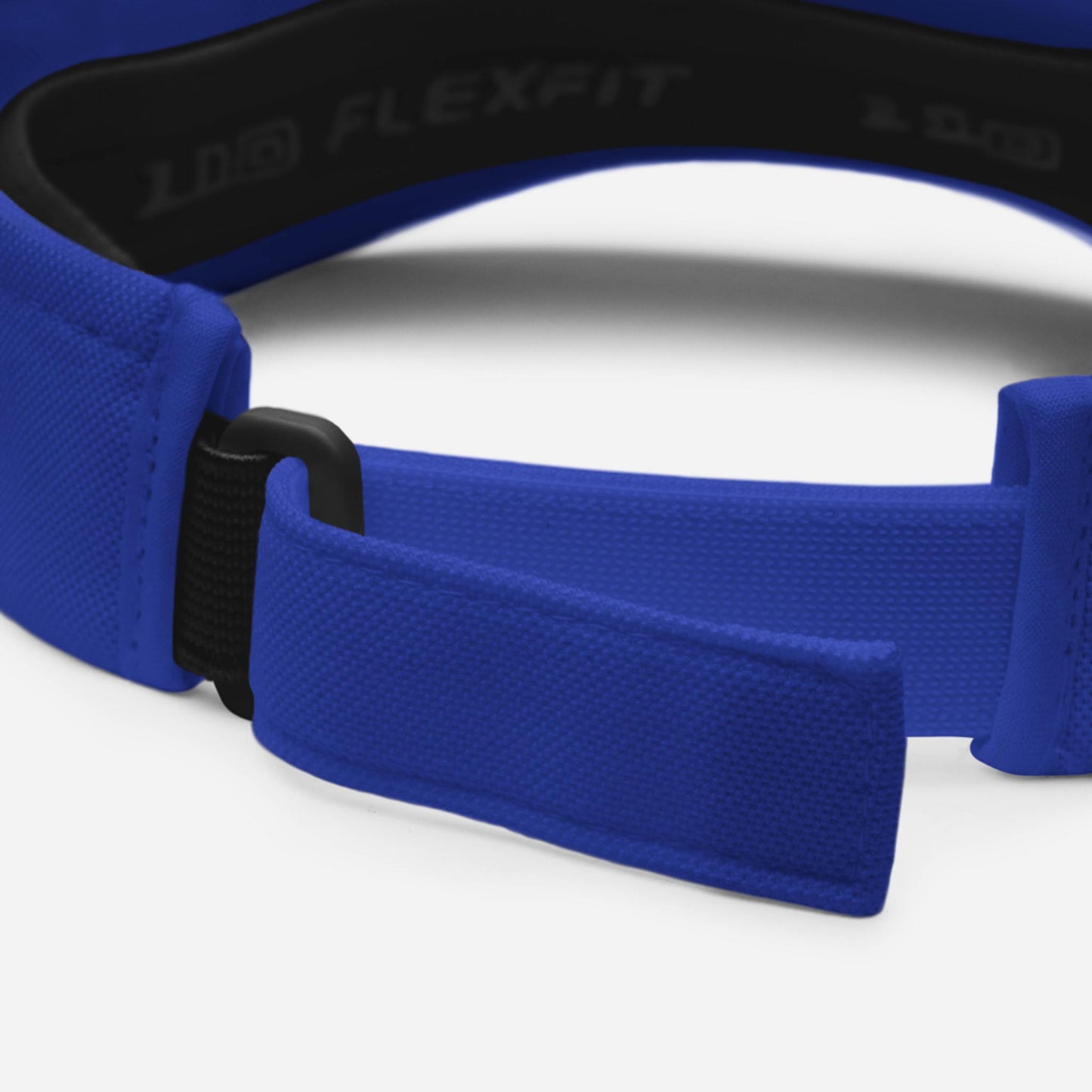 Close-up of the adjustable strap and buckle on a blue Mambí Flexfit cap, highlighting the fabrics texture and inside branding.