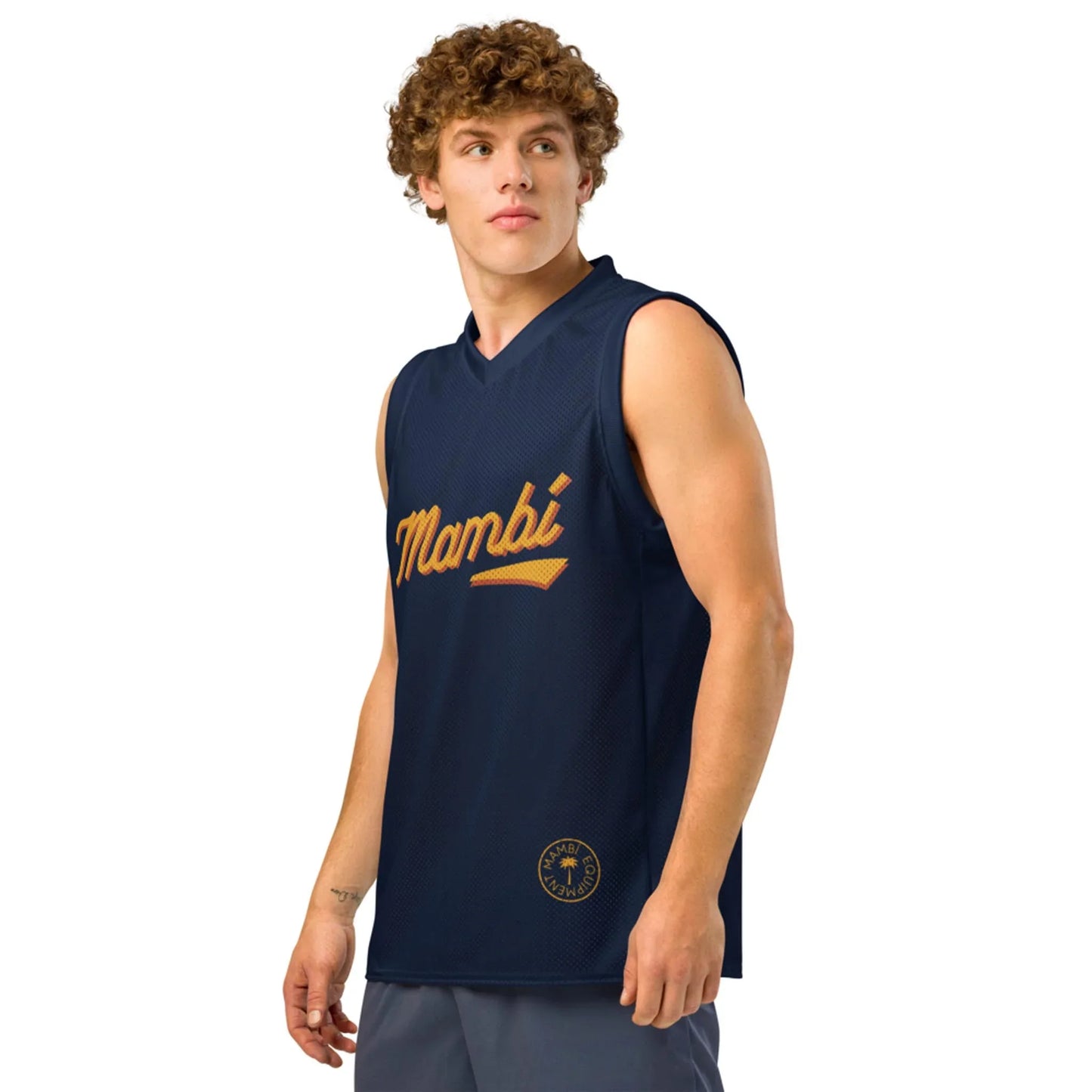 A young man with curly brown hair wears a sleeveless navy athletic jersey with Mambí written in gold script, standing against a plain white background and looking slightly to his left.