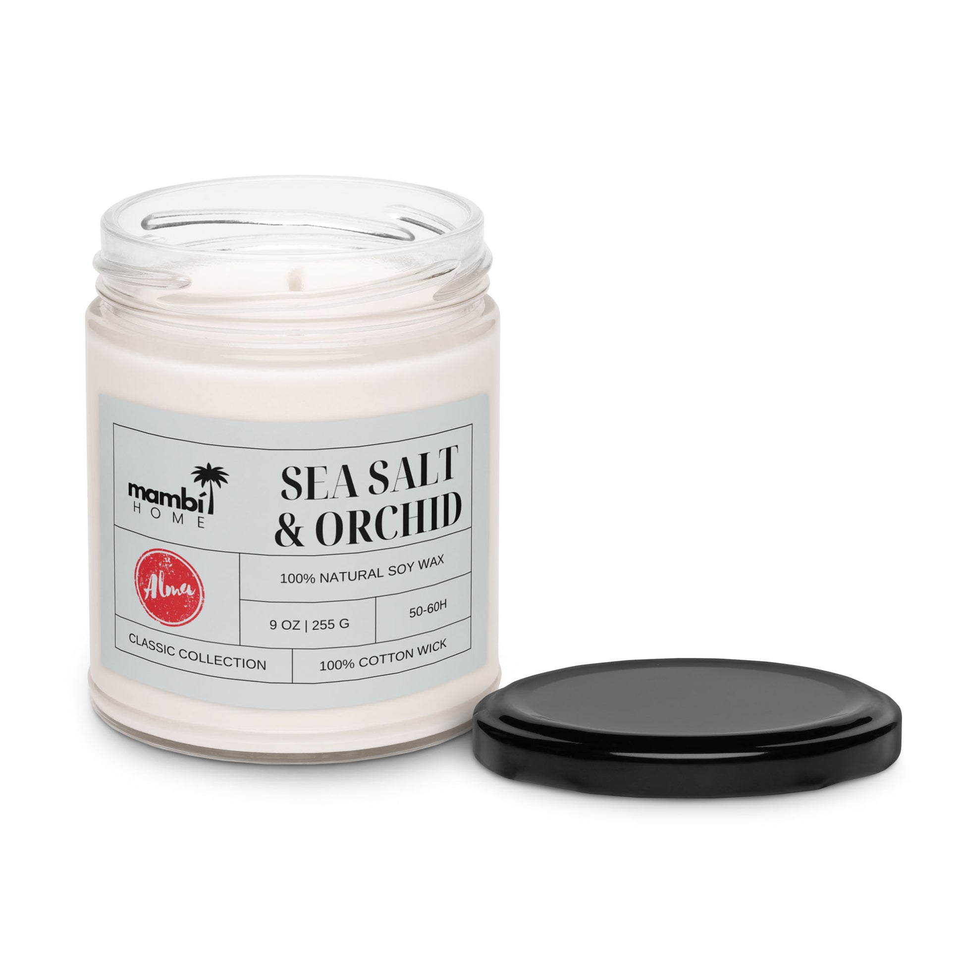 A glass jar candle labeled mambi HOME Sea Salt & Orchid, made with 100% natural soy wax for a long burn time. This 9 oz scented soy candle features a 100% cotton wick, and the black lid rests beside the jar on a white background.