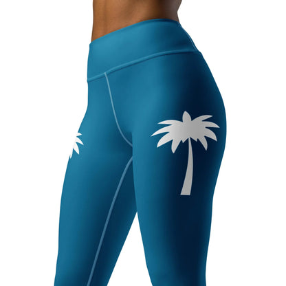 A model wears the Printful Alpine High-Rise Yoga Leggings for women in teal, featuring white palm tree graphics on the upper thighs, shown waist down against a white backdrop—ideal for athleisure style.