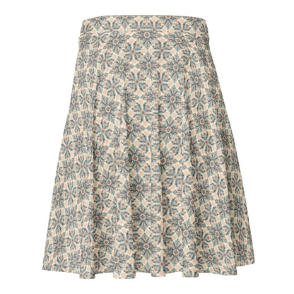 A knee-length A-line skirt featuring an intricate blue and grey floral geometric pattern on a beige background. The Mambí skirt has a fitted waistband and flows outward toward the hem.