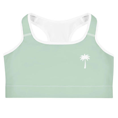 Light green Mambí sports bra with white trim and a simple white palm tree graphic on the left chest, displayed against a white background.