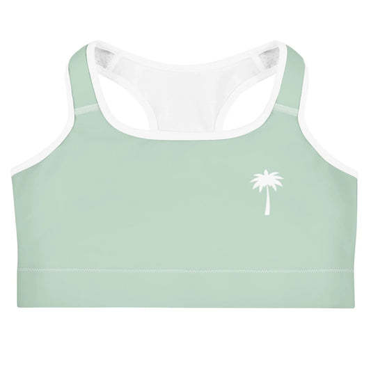 Light green Mambí sports bra with white trim and a simple white palm tree graphic on the left chest, displayed against a white background.