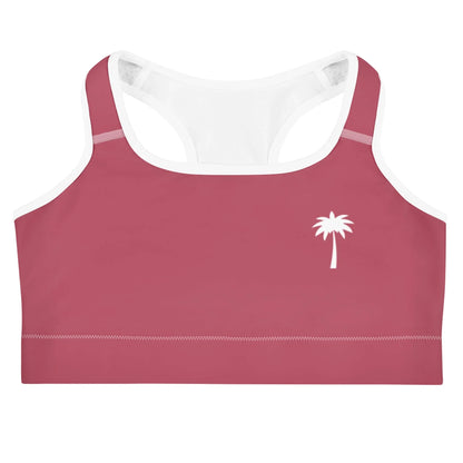 A maroon Mambí sports bra with white trim and a small white palm tree graphic on the left chest. It features a racerback design and a wide elastic band at the bottom.