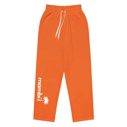 Bright orange sweatpants with a white drawstring and Mambí text next to a palm tree graphic printed in white on the lower left leg. The pants are laid flat on a white background.