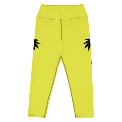 Part of the Printful activewear line, the Aventura High-Rise Yoga Capri Leggings for women feature yellow hues, four-way stretch fabric, and bold black palm leaf graphics on a white base along the outer thighs.