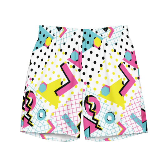 Colorful Mambí shorts with a bold 1980s-inspired pattern, featuring pink, yellow, and blue geometric shapes, black polka dots, squiggles, and grid lines on a white background.