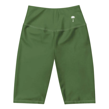 Green high-waisted athletic shorts with a small white palm tree graphic on the left hip and a smooth finish, featuring Mambí style. The shorts reach just above the knee.