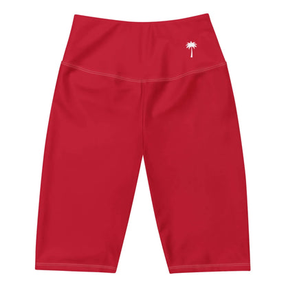 Red knee-length athletic shorts with a high waistband and a small white palm tree graphic on the left hip. The Mambí-inspired design is displayed flat against a white background.