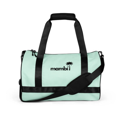 A light mint green Mambí duffel bag with black handles, an adjustable shoulder strap, and black accents. The word Mambí and a small palm tree graphic are printed in black on the front.