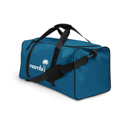 A blue duffel bag with black straps and a shoulder pad. The bag features a white palm tree logo and the word Mambí on the side. The background is plain white.