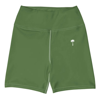 The Brickell Yoga Shorts for women by Printful are green, high-waisted, feature white stitching, a small white palm tree graphic on the left thigh, a four-way stretch, and are shown laid flat on a white background.