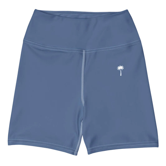 The Brickell Yoga Shorts by Printful feature a blue high-waist design, white stitching, a small white palm tree on the left thigh, and four-way stretch for comfort. Displayed on a plain white background.
