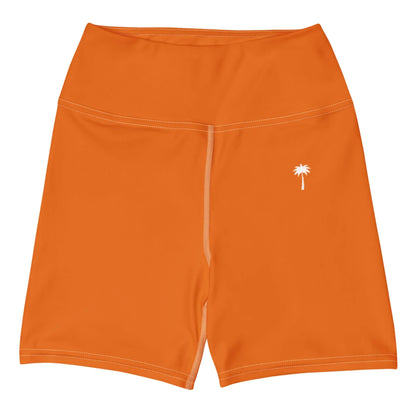 The Brickell Yoga Shorts by Printful are high-waisted, orange, feature four-way stretch fabric, white stitching, and a small white palm tree graphic near the left waistband.