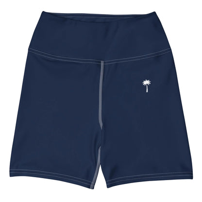 The Brickell Yoga Shorts by Printful are navy blue with a high waistband, white stitching, and a small white palm tree logo on the left thigh.