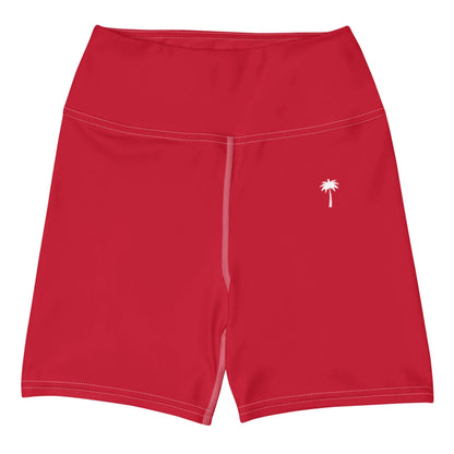 Printful Brickell Yoga Shorts for women in bright red, featuring high-waisted fit, four-way stretch, white stitching, and a small white palm tree graphic on the left leg. Shown flat on a white background.
