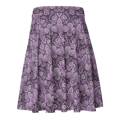 The Candelaria Skater Skirt by Printful is a flared, knee-length skirt with a purple and white floral paisley pattern, flowy design, and no visible waistband or fastenings for a flattering silhouette.