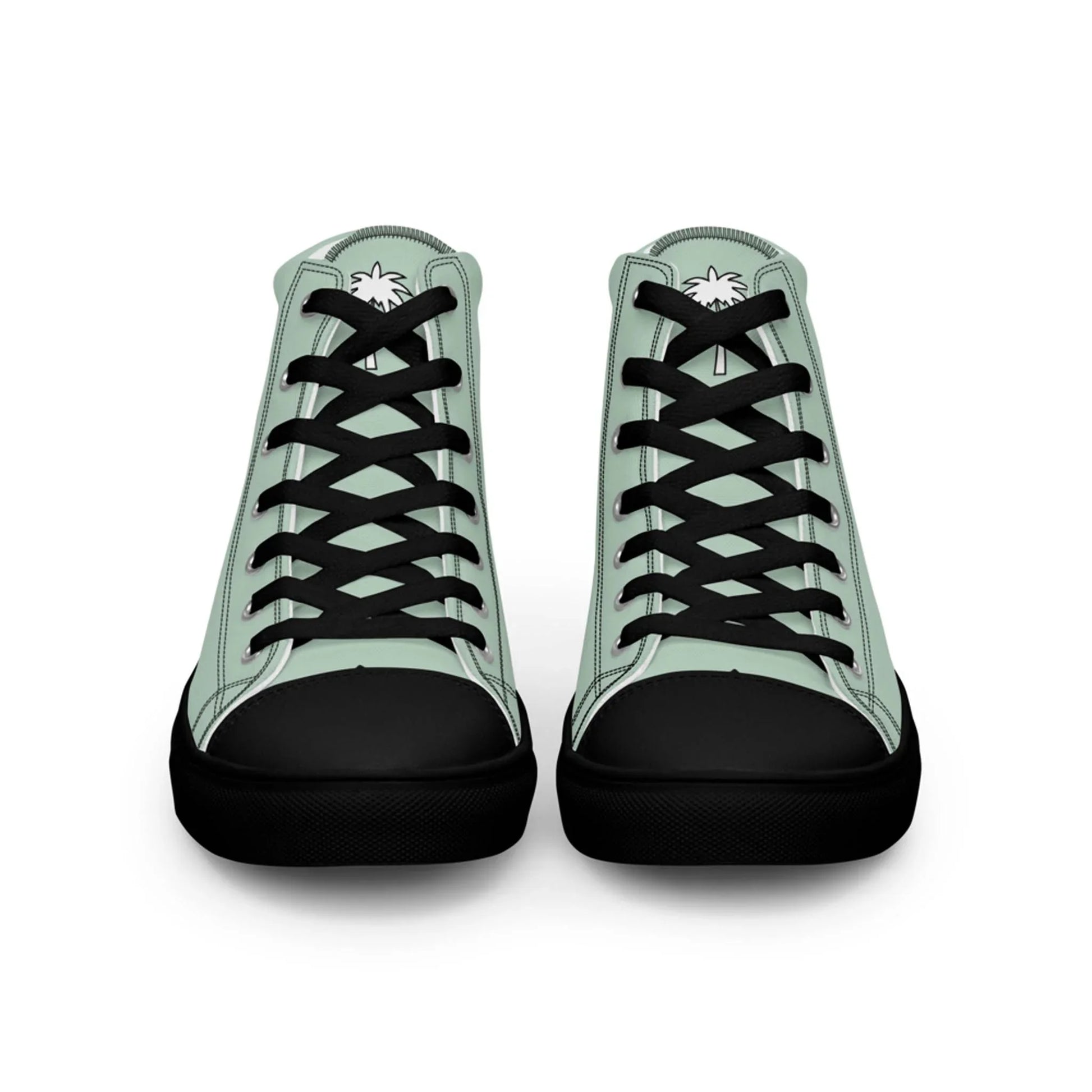 A pair of high-top Mambí sneakers with light green sides, black laces, black toes and soles, and a white palm tree graphic on each tongue, shown from the front against a white background.