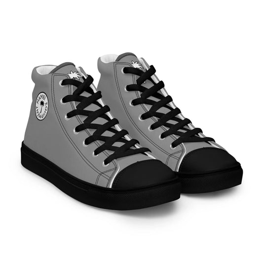 A pair of high-top sneakers with gray sides, black laces, black toe caps, and black soles. The ankle area features a round white Mambí logo with a palm tree design.