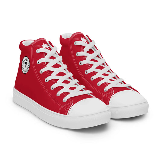 A pair of red high-top Mambí sneakers with white laces, white toe caps, and white soles. Each shoe features a circular black and white logo with a palm tree design on the ankle area.