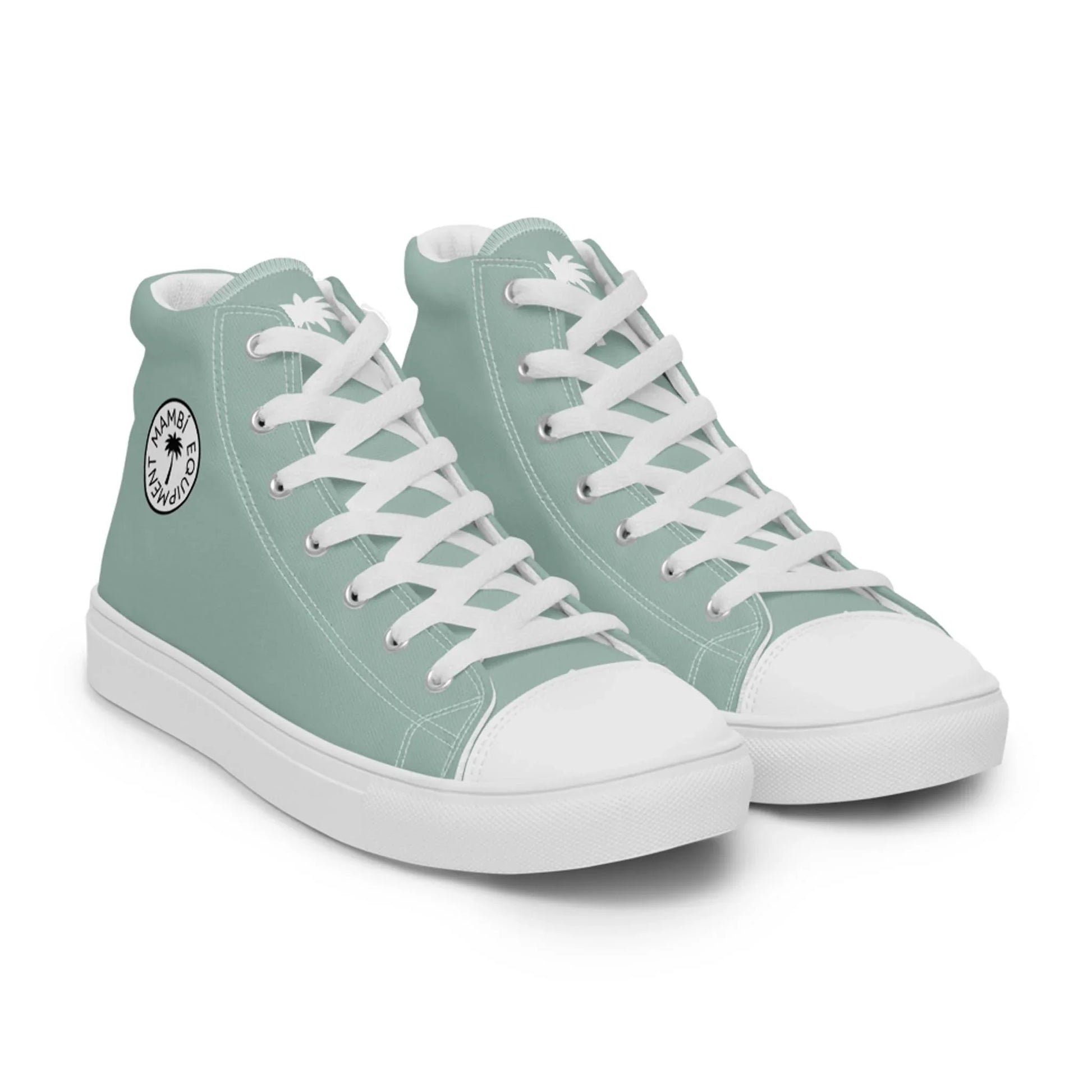 A pair of light teal Mambí high-top sneakers with white laces, white soles, and a circular black and white logo on the ankle area.