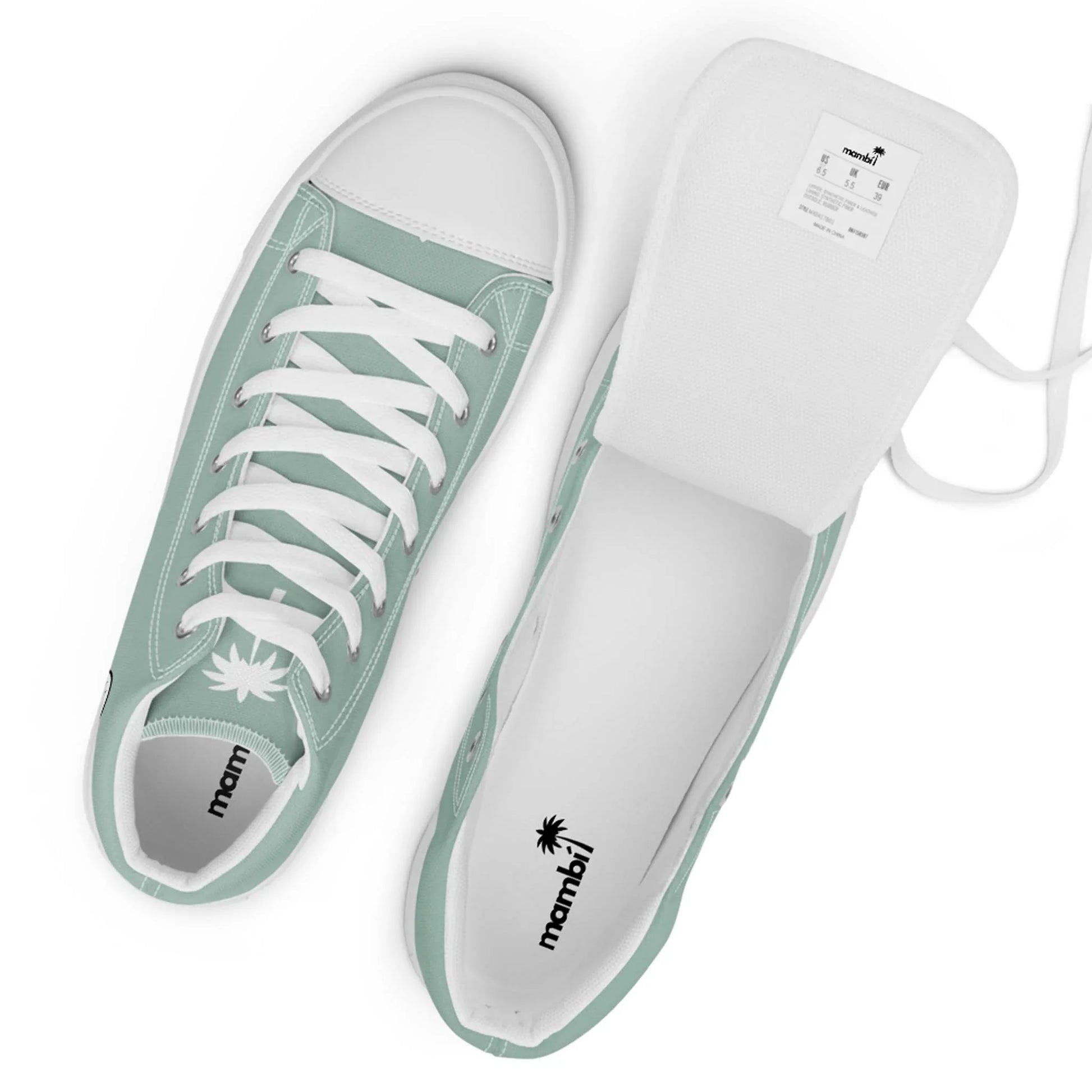 A pair of mint green Mambí low-top sneakers with white laces, white rubber toe caps, and white interiors. One shoe stands upright while the other rests on its side with the tongue pulled out to reveal the label.