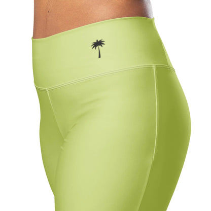 A person models Printfuls Carolina Flared Performance Leggings for women in high-waisted, butt-lifting lime green with a small black palm tree logo on the waistband. The background is white.