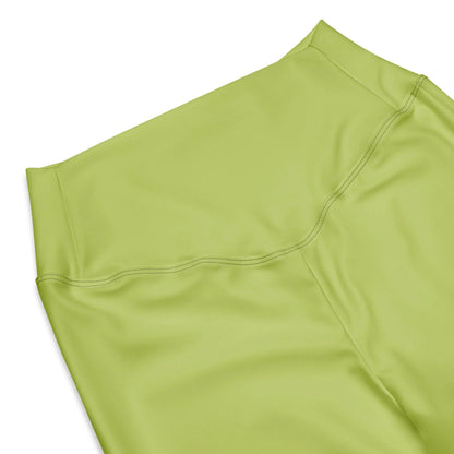 A close-up of the high waist and upper section of Printful Carolina Flared Performance Leggings for women in light green, highlighting smooth fabric and detailed stitching against a white background.