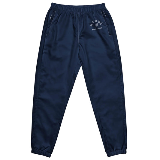 Navy blue Mambí track pants with an elastic waistband and cuffs, side pockets, and a small white graphic with text on the left thigh. The pants are laid flat on a white background.