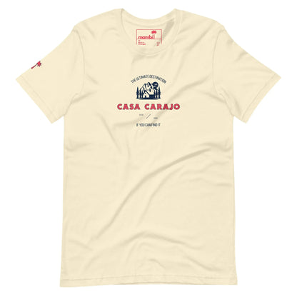 Cream-colored t-shirt featuring a blue and white house graphic, red palm tree logo on the sleeve, and bold red CASA CARAJO lettering with Mambí flair, topped by THE ULTIMATE DESTINATION in smaller text.