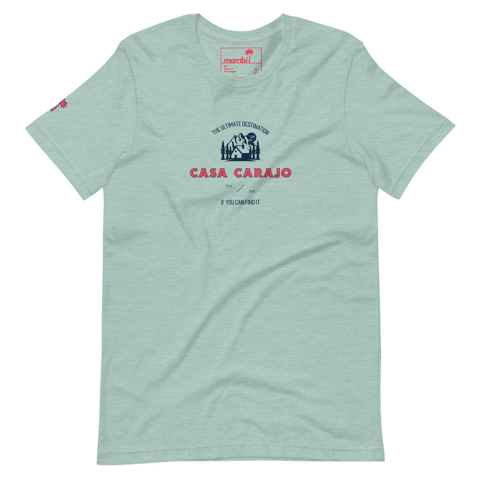 Light green Mambí T-shirt featuring a dark blue and red graphic with “Casa Carajo” text, smaller lettering above and below, and a small palm tree logo on the left sleeve.