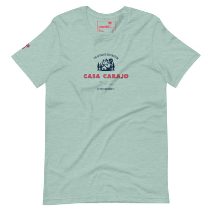 Light green Mambí T-shirt featuring a dark blue and red graphic with “Casa Carajo” text, smaller lettering above and below, and a small palm tree logo on the left sleeve.