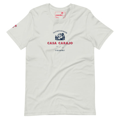 White t-shirt with a graphic featuring a small illustrated house, the text The Ultimate Destination, Casa Carajo, and a nod to Mambí spirit. Small red palm tree on the left sleeve.