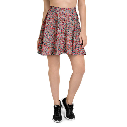 A person wearing a high-waisted, flared Mambí skirt with a small red and blue floral pattern, black athletic shoes, and a crop top. The photo is cropped from the shoulders down.