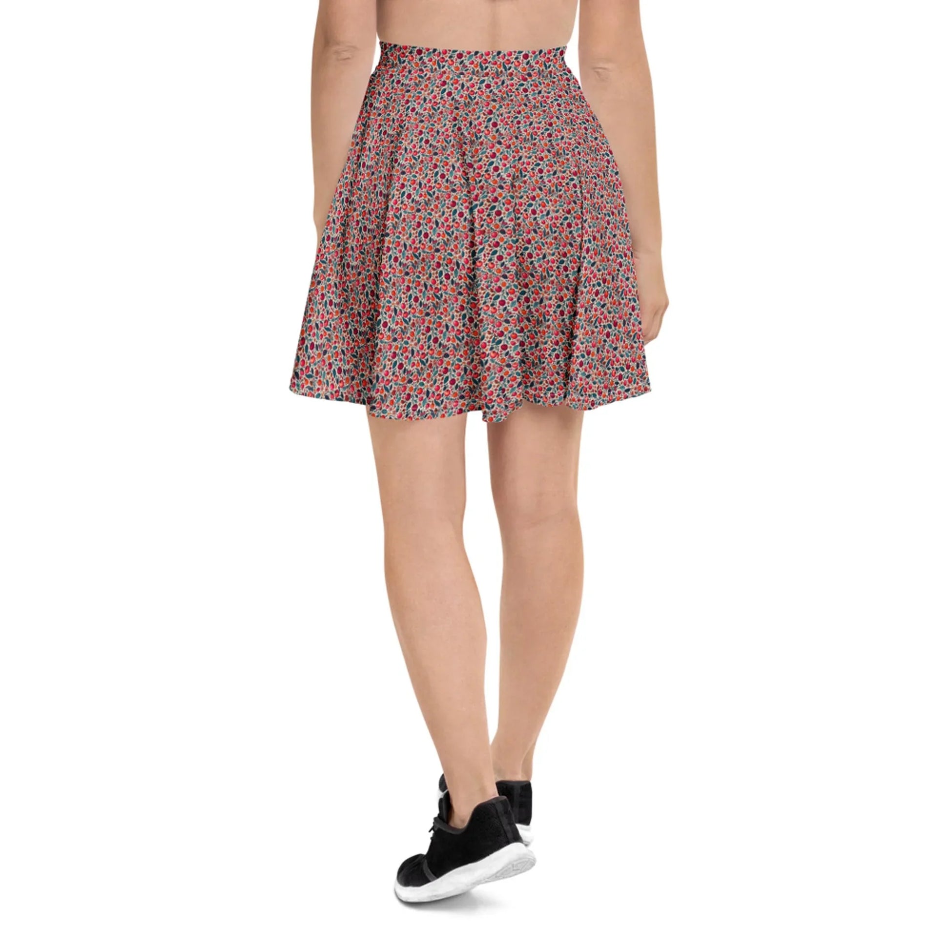 A person wearing a red and black Mambí floral-patterned flared skirt and black sneakers, seen from the back against a plain white background.